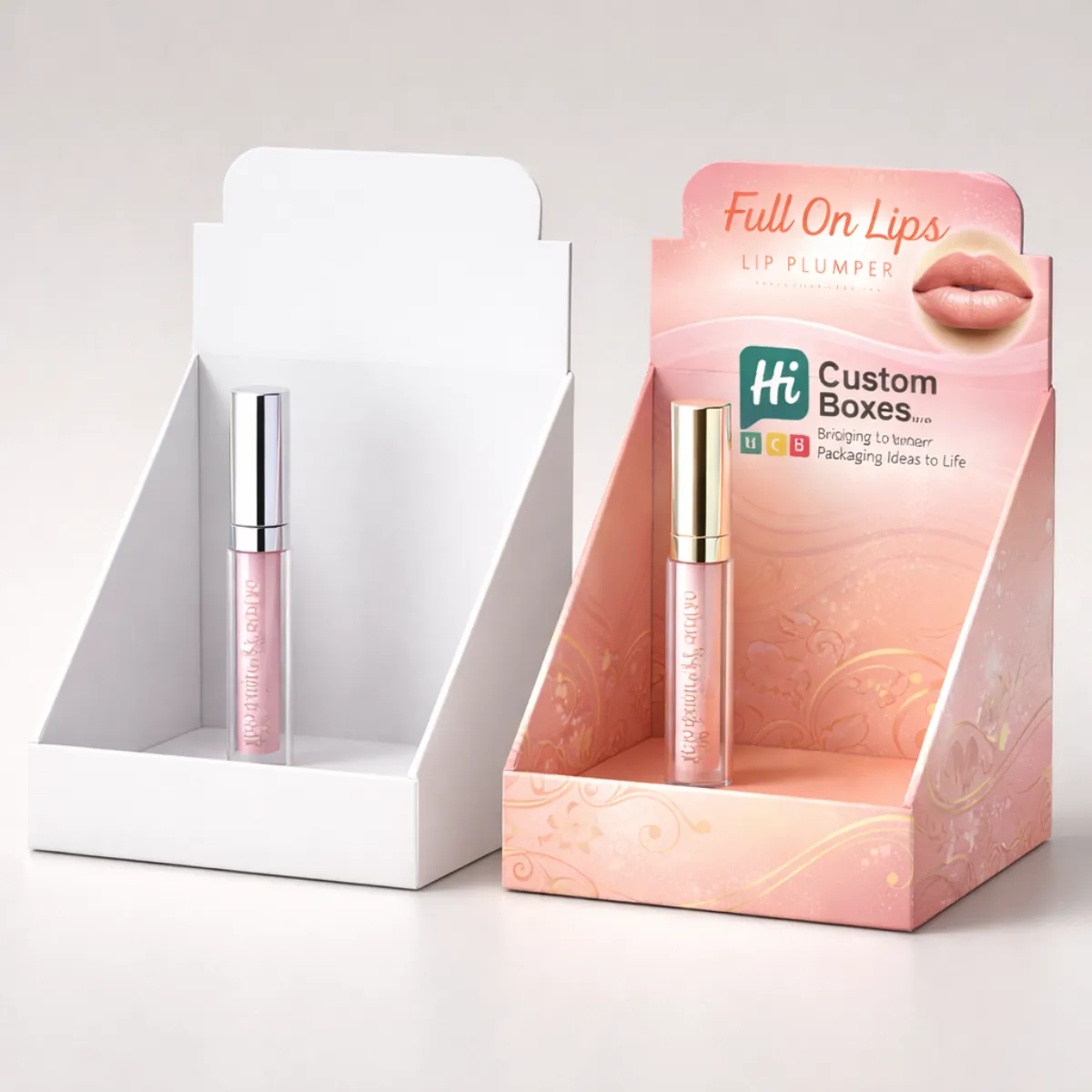 Two cardboard counter display units showcasing lip plumper tubes, one plain white and one fully branded. class=